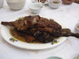 Boros libapecsenye: Sült liba ropogós bőrrel és barna mártással tálalva egy fehér tányéron.