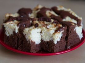 Boci szelet sütemény csokoládés tésztával és túrós töltelékkel egy piros tányéron.