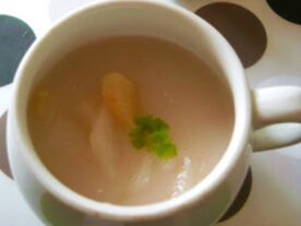 Krémes birsalma leves egy mintás csészében, friss petrezselyemmel díszítve.