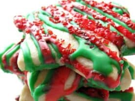 "Karácsonyi sütemény halom piros és zöld mázzal és szórással díszítve, ünnepi hangulatot sugallva.